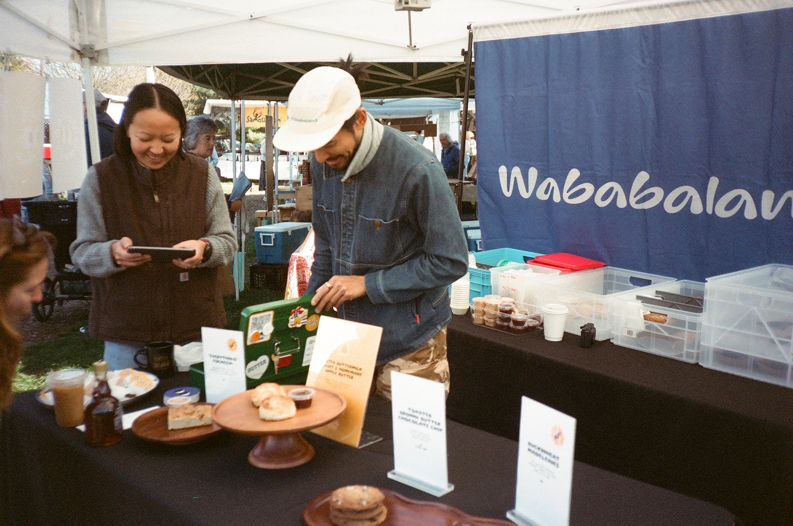Photo of two women and a man talking in the corner of a room with modern furniture.