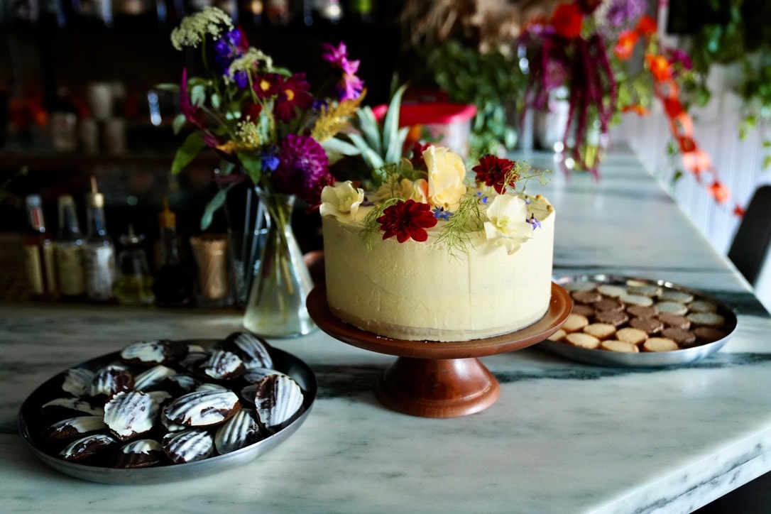 Two women sitting at a modern table talking with a city view behind them.
